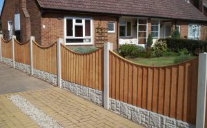 Curved wooden fence with stone base complementing the brick home exterior, showcasing a cohesive and matching fence with home exterior design.