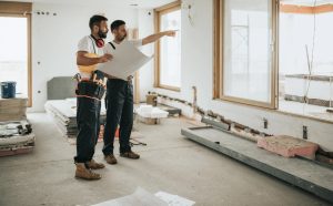 Contractors reviewing blueprints and planning construction work in a home renovation project, representing the Best Remodeling Services.