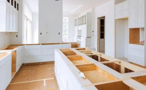 This image showcases a kitchen in the midst of a remodel, featuring white cabinetry and open spaces, ideal for showcasing kitchen remodeling services.