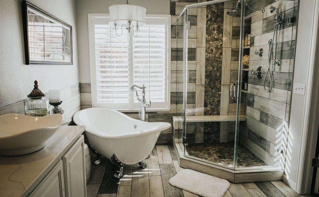 A modern bathroom featuring a freestanding clawfoot tub, a glass-enclosed shower, and elegant finishes, exemplifying the results delivered by the Best Bathroom Remodelling Services.
