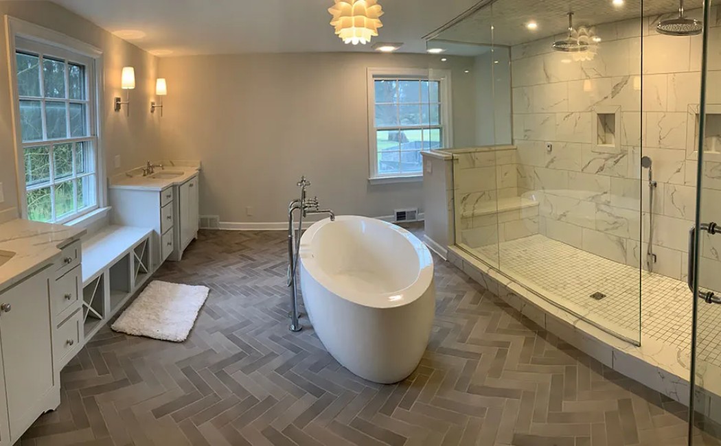 A spacious modern bathroom with dual vanities, a freestanding tub, and a large glass-enclosed shower, showcasing the quality delivered by the Best Bathroom Remodelling Services.