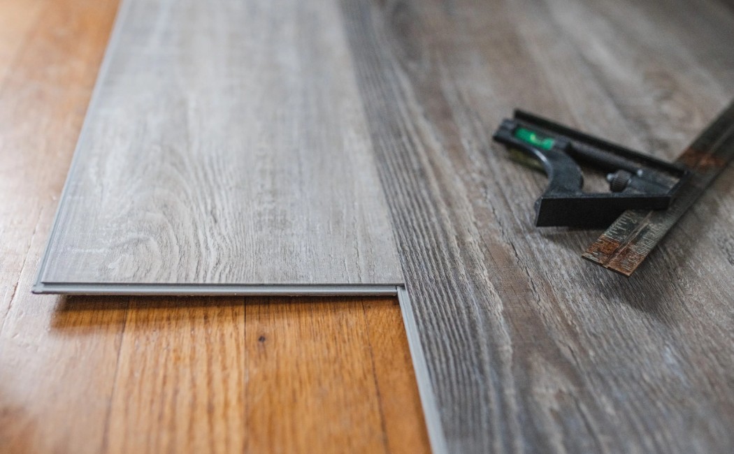 Close-Up of Professional LVP Flooring Installation with Precision-Fit Planks Close-up of professional LVP flooring installation, showing precision-fit vinyl planks over a wood subfloor for a durable, modern finish.