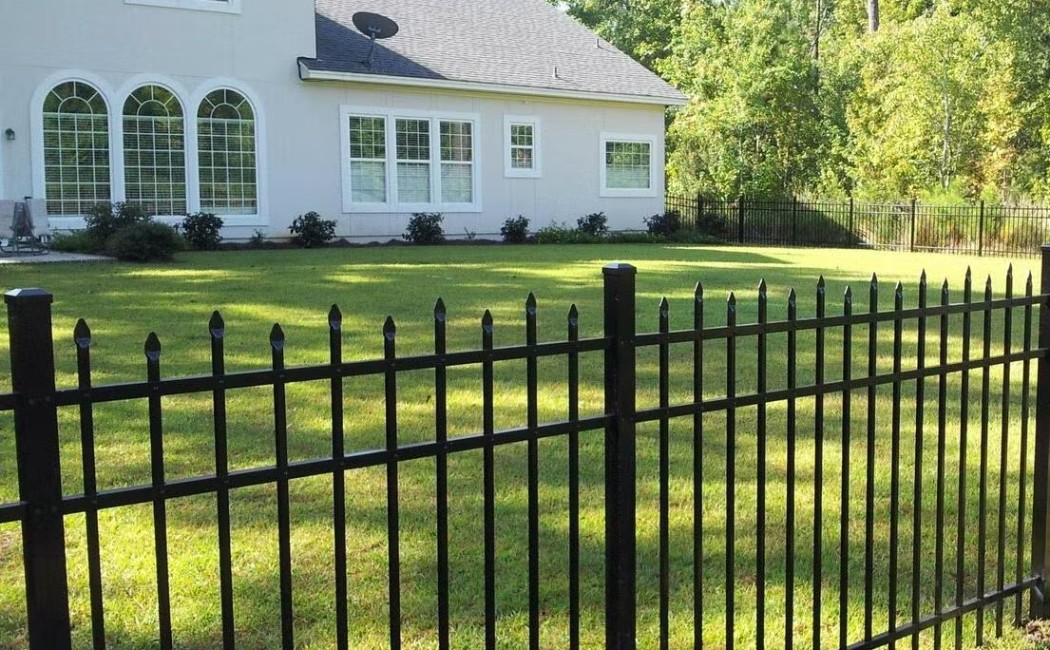 Black Metal Fence Installation Enhancing Home Security and Curb Appeal Black metal fence installed around a residential lawn, highlighting professional Fence Building Services for security and curb appeal.