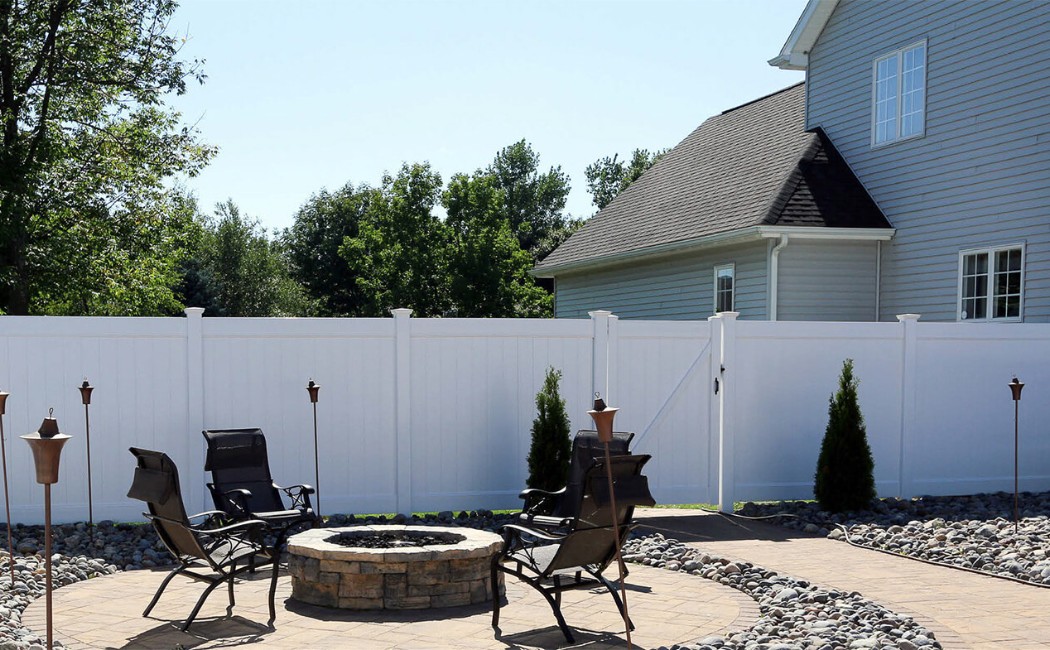 White Privacy Fence Installation for Secure and Comfortable Outdoor Spaces White privacy fence enclosing a backyard patio and seating area, showcasing professional Fence Building Services for security and outdoor comfort.