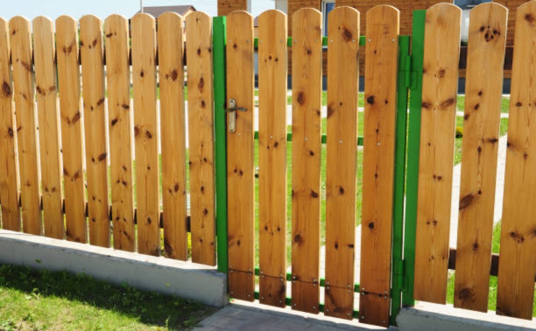 Wooden backyard gate and fence with vertical panels installed as part of a residential Fence Installation project.